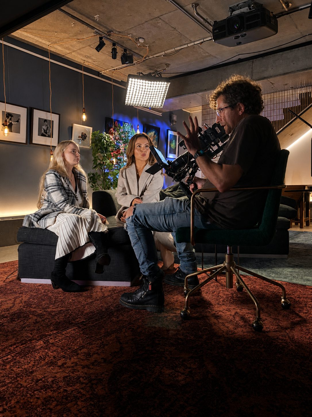 Dean Francis talking with two students in front of a wall of framed portrait photography