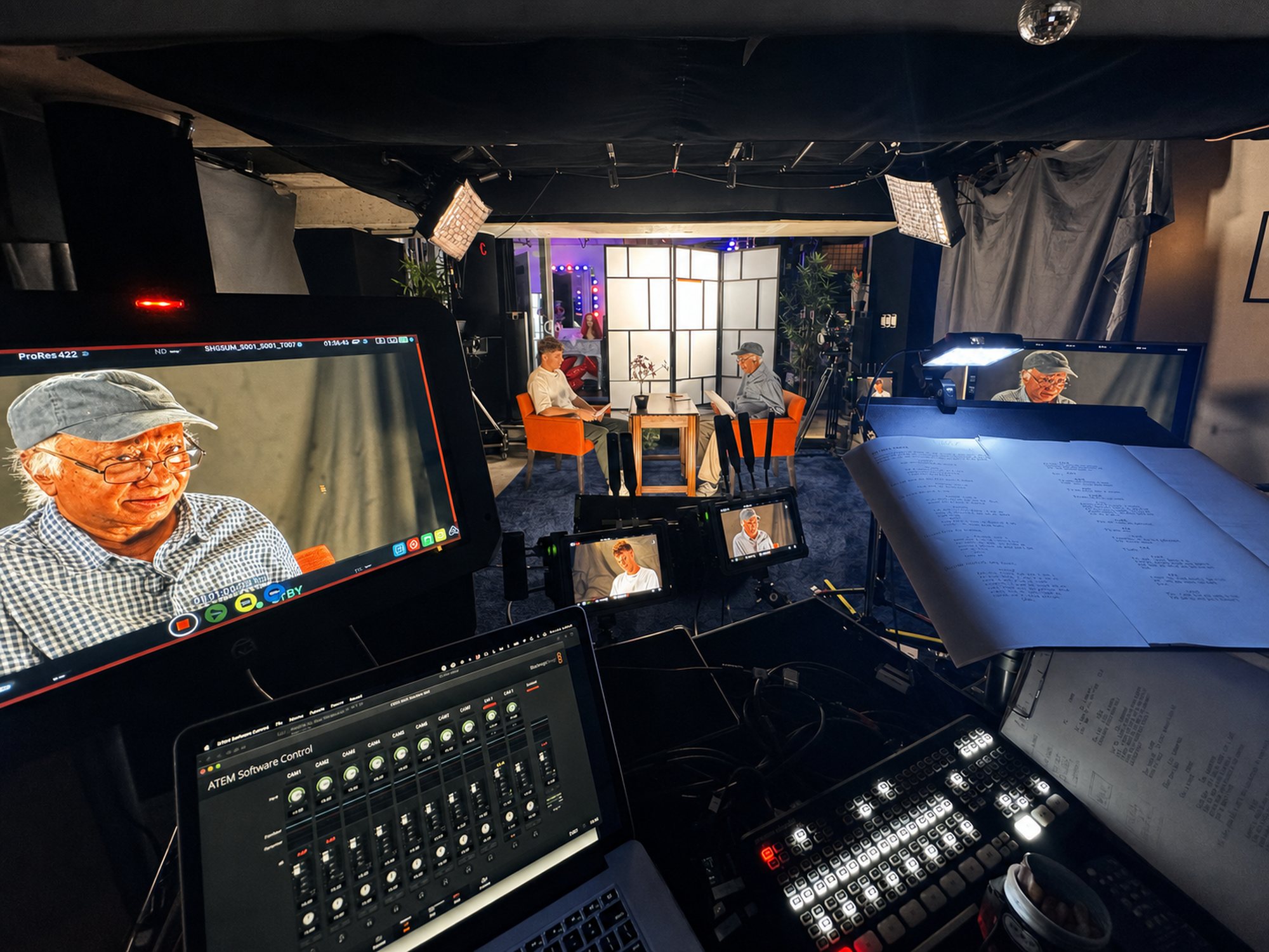 Script pages under a work light with a scene playing on the studio monitor at JJ Splice